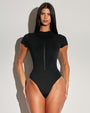 Model wears Short Sleeve Surfy One Piece Sculpting Shapewear Swimsuit - Black front view zipped all the way up