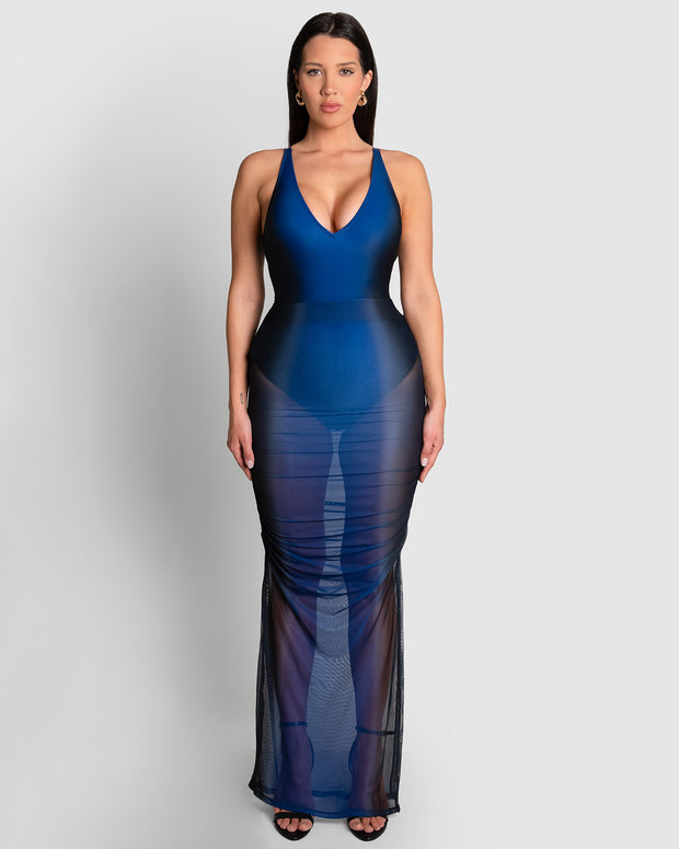 Model is wearing Ruched Sheer Side Slit Maxi Skirty - Midnight Ombre and matching color one piece swimsuit