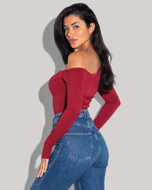 Model is posing in Shapey Long Sleeve One Shoulder Sculpting Shapewear Top - Ruby tucked in view