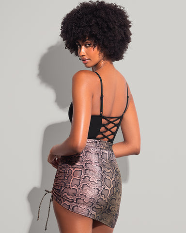 Model wears Skirty Waterproof & Sunproof Shapewear Mini Cover-Up - Ombre Snake and one piece black swimsuit back view