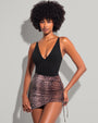 Model wears Skirty Waterproof & Sunproof Shapewear Mini Cover-Up - Ombre Snake and one piece black swimsuit